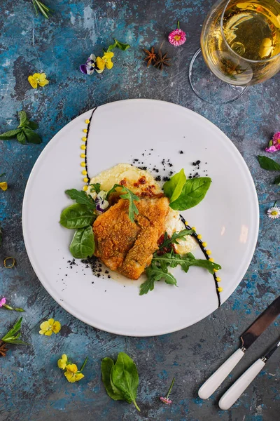 Beyaz tabakta sebze garnitür ile servis edilen kızarmış ekmekli balık