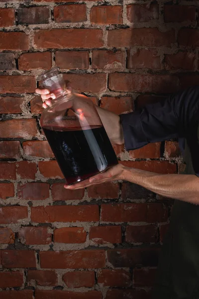 man holding jar with wine