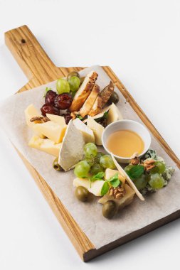 ahşap tahta üzerinde çeşitli peynir ve bal