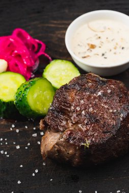 ızgara biftek, dilimlenmiş salatalık ve sos
