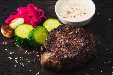 ızgara biftek, dilimlenmiş salatalık ve sos