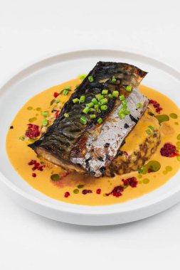 beyaz tabakta soslu pişmiş balık 