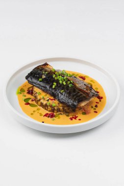 beyaz tabakta soslu pişmiş balık 