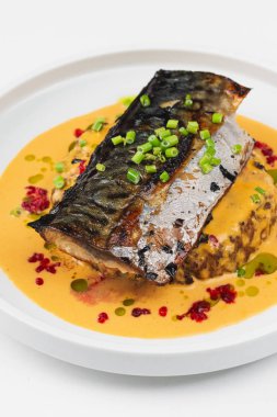 beyaz tabakta soslu pişmiş balık 