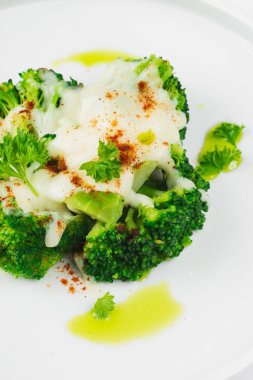 beyaz tabakta peynir soslu brokoli