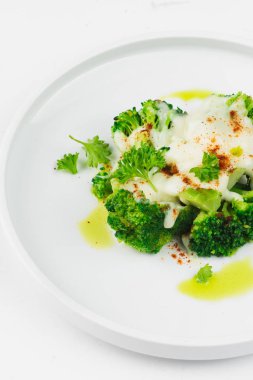 beyaz tabakta peynir soslu brokoli