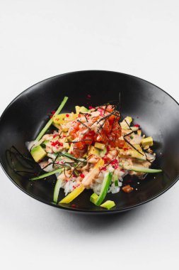 beyaz bir arka plan üzerinde siyah tabakta salata