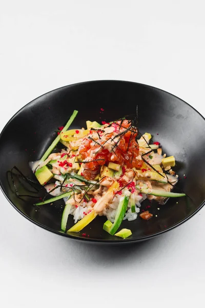 beyaz bir arka plan üzerinde siyah tabakta salata