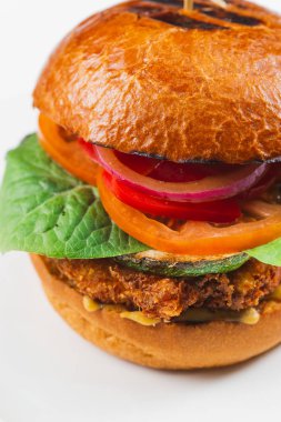 Beyaz arka planda domates ve sığır etli lezzetli bir hamburger.