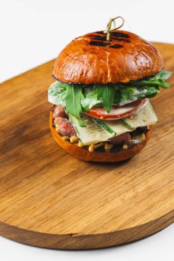 Beyaz arka planda domates ve sığır etli lezzetli bir hamburger.