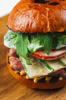 Beyaz arka planda domates ve sığır etli lezzetli bir hamburger.