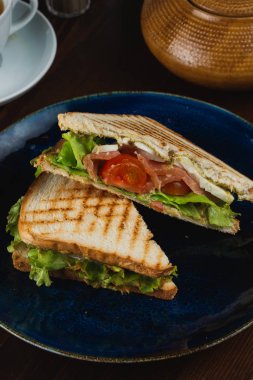 Tabakta lezzetli sandviç ve çay.