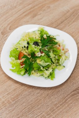 Tahta bir masada taze sebze salatası.