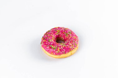 Arkaplanda pembe beyaz çikolata olan çörek.