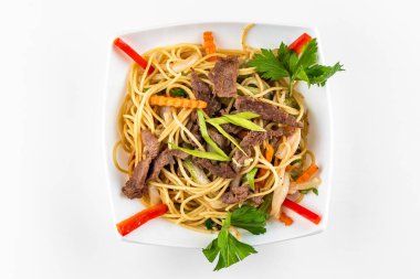 Asya usulü kızartma, sebze ve beyaz tabakta erişte.