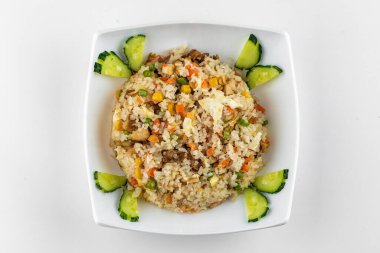 Beyaz arka planda tavuk ve sebzeli kızarmış pirinç.