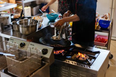 Şef mutfakta yemek pişiriyor.