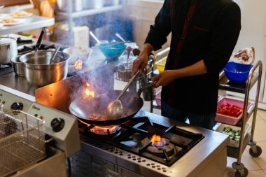 Şef mutfakta yemek pişiriyor.