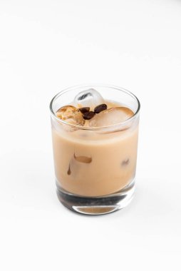 Beyaz masa arkasında bir bardak sütlü kahve ve alkollü kokteyl.