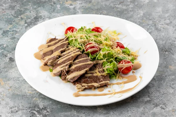 배경에 접시에 고기를 세자르 샐러드 가까이 — 스톡 사진