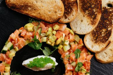 Sebze salatası ve ızgara ekmek dilimleriyle kesme tahtası.