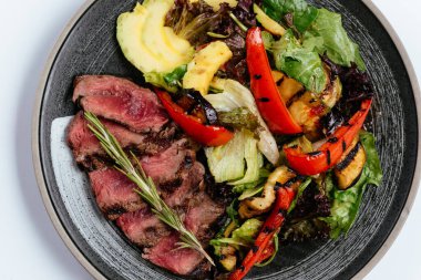 Izgara sebzeler ve siyah tabakta ızgara et. 