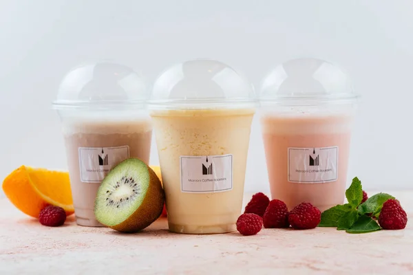 Plastic glasses with fruits smoothie, healthy drinks in to go cups