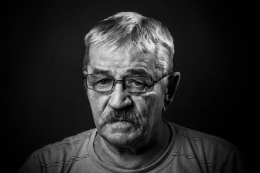 Gözlüklü ve kamuflajlı yaşlı adam.