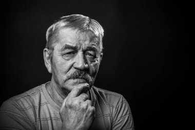 Gözlüklü ve kamuflajlı yaşlı adam.