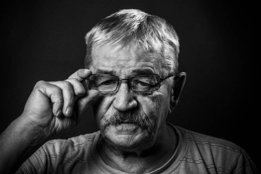 Gözlüklü ve kamuflajlı yaşlı adam.