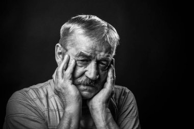 Gözlüklü ve kamuflajlı yaşlı adam.