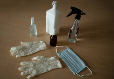 Virüslere karşı önlemlerin görüntüsü. Coronavirus dezenfeksiyonu. Covid-19 'dan koruma. Beyaz tıbbi eldivenler, tıbbi maske, alkol spreyi dezenfektan ve antiseptik, sıvı maddeler için konteynır..