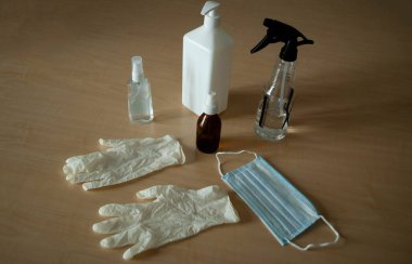 Virüslere karşı önlemlerin görüntüsü. Coronavirus dezenfeksiyonu. Covid-19 'dan koruma. Beyaz tıbbi eldivenler, tıbbi maske, alkol spreyi dezenfektan ve antiseptik, sıvı maddeler için konteynır..