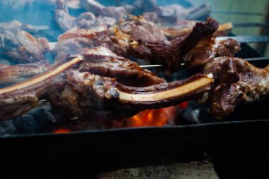 Metal bir şişte barbekü yapmak. Barbeküde ızgara et. Dilimlere kesilmiş taze et şişleri. Geleneksel doğu yemeği, barbekü. Kömür ve alev ızgarası, piknik, sokak yemeği.