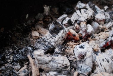 Izgaranın üzerindeki kömürlerin külleri. Et kebabı kızartmak için kundakladıktan sonra ızgarada kömür yakmak.