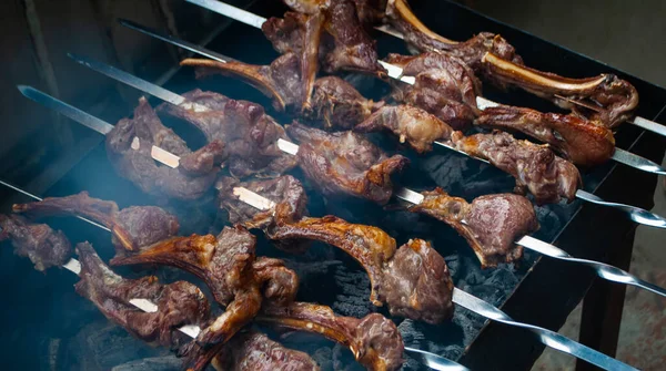 Metal bir şişte barbekü yapmak. Barbeküde ızgara et. Dilimlere kesilmiş taze et şişleri. Geleneksel doğu yemeği, barbekü. Kömür ve alev ızgarası, piknik, sokak yemeği.