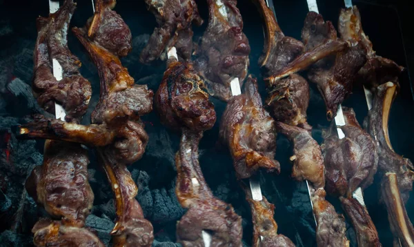 Metal bir şişte barbekü yapmak. Barbeküde ızgara et. Dilimlere kesilmiş taze et şişleri. Geleneksel doğu yemeği, barbekü. Kömür ve alev ızgarası, piknik, sokak yemeği.