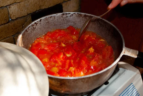 Cooking tomato in a frying pan. Frying tomato in iron pan. Stir-fried tomato for scrambled eggs