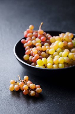 Üzüm siyah bir taş zemin üzerine kase. Kopya alanı.