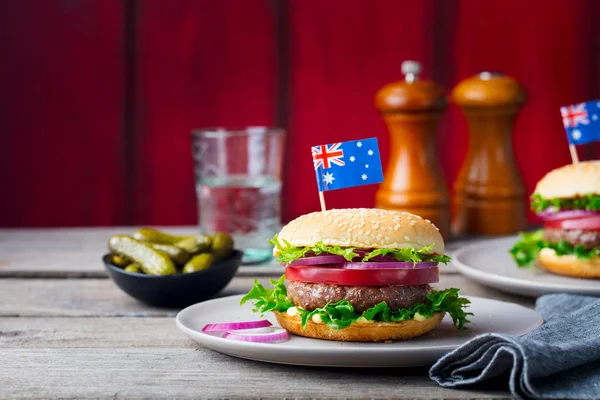 Burger with Australian flag on top. Wooden background.