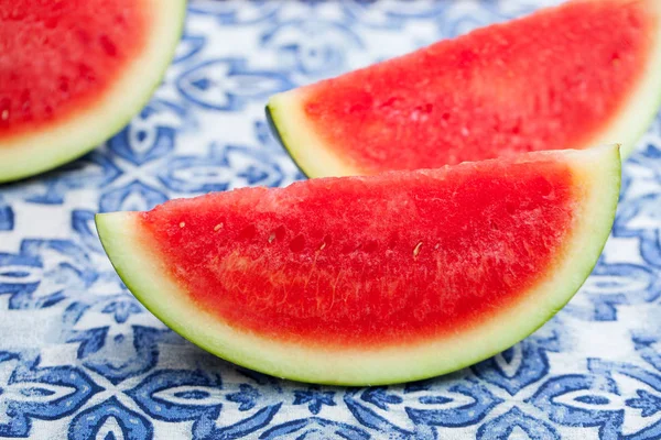 Watermelon slices on blue textile background. Fresh organic product. Close up.