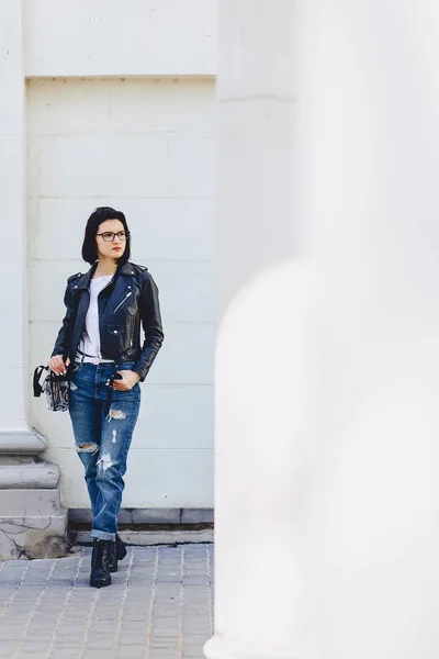 シンプル背景で路上のレザー ジャケットのメガネの女 — ストック写真