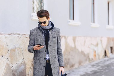 Güneş gözlüğü ile telefon şık genç adam sokakta yürümek