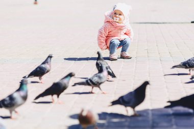 küçük şirin bebek yürüyüşü meydanda kuşlarla güneşli günde