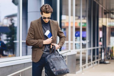 Pasaport ve bilet Street Kentsel bağlamda ceketli şık çekici gezgin