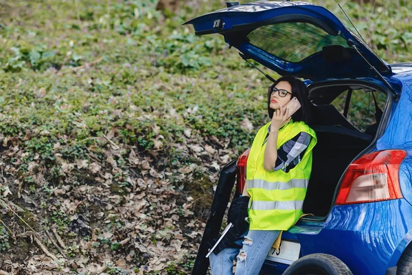 魅力的な女の子の安全のジャケットでは 道路上の車の近く電話での話し — ストック写真