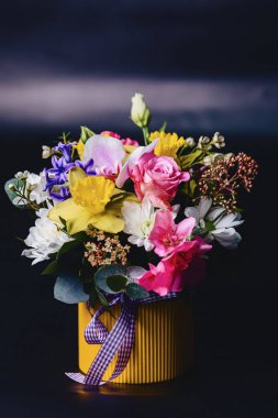 sepette koyu arka plan üzerinde renkli çiçek buketi