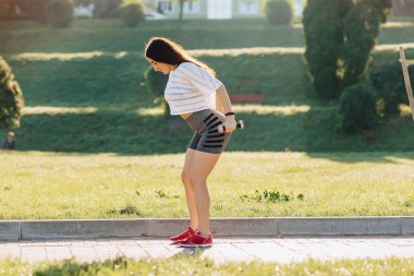 çim dışında gün batımında dumbbells ile egzersizleri yapma rahat fitness kız