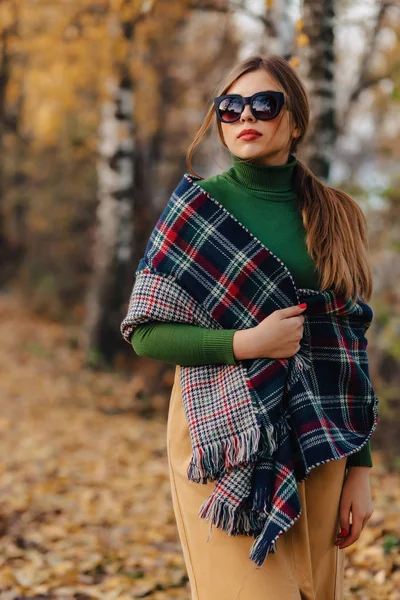 cozy stylish young girl walk at autumn colorful park in sunglasses alone