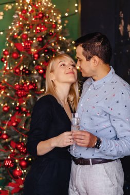 Sevgi dolu güzel birkaç bardak şampanya arka planı ile yeni yıl kutlama bir Noel ağacı